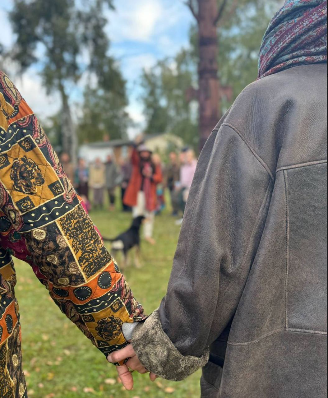 Zwei Menschen halten Händchen in Hippie-Kleidung