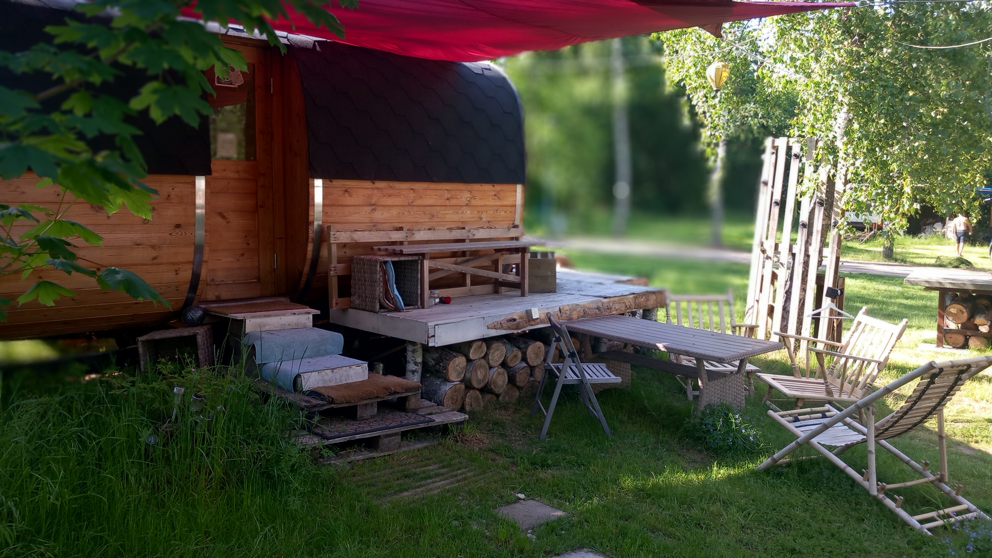 Fasssauna mit Terrasse, Sonnensegel und gemütlicher Sitzecke